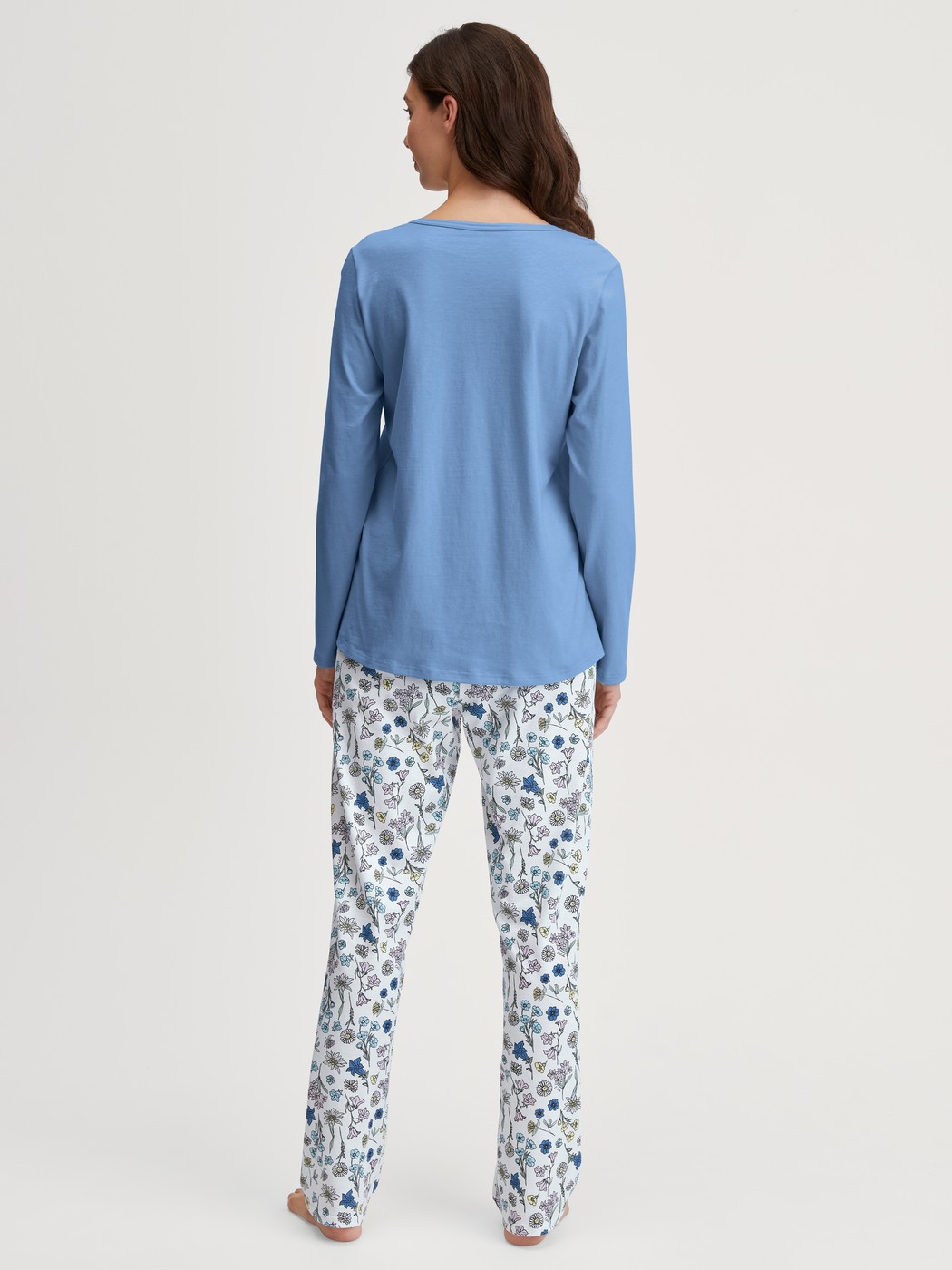 Damen-Model trägt Pyjama, lang aus 100% Baumwolle in Blau, Floral aus Serie Flower Nights von CALIDA, Rückansicht