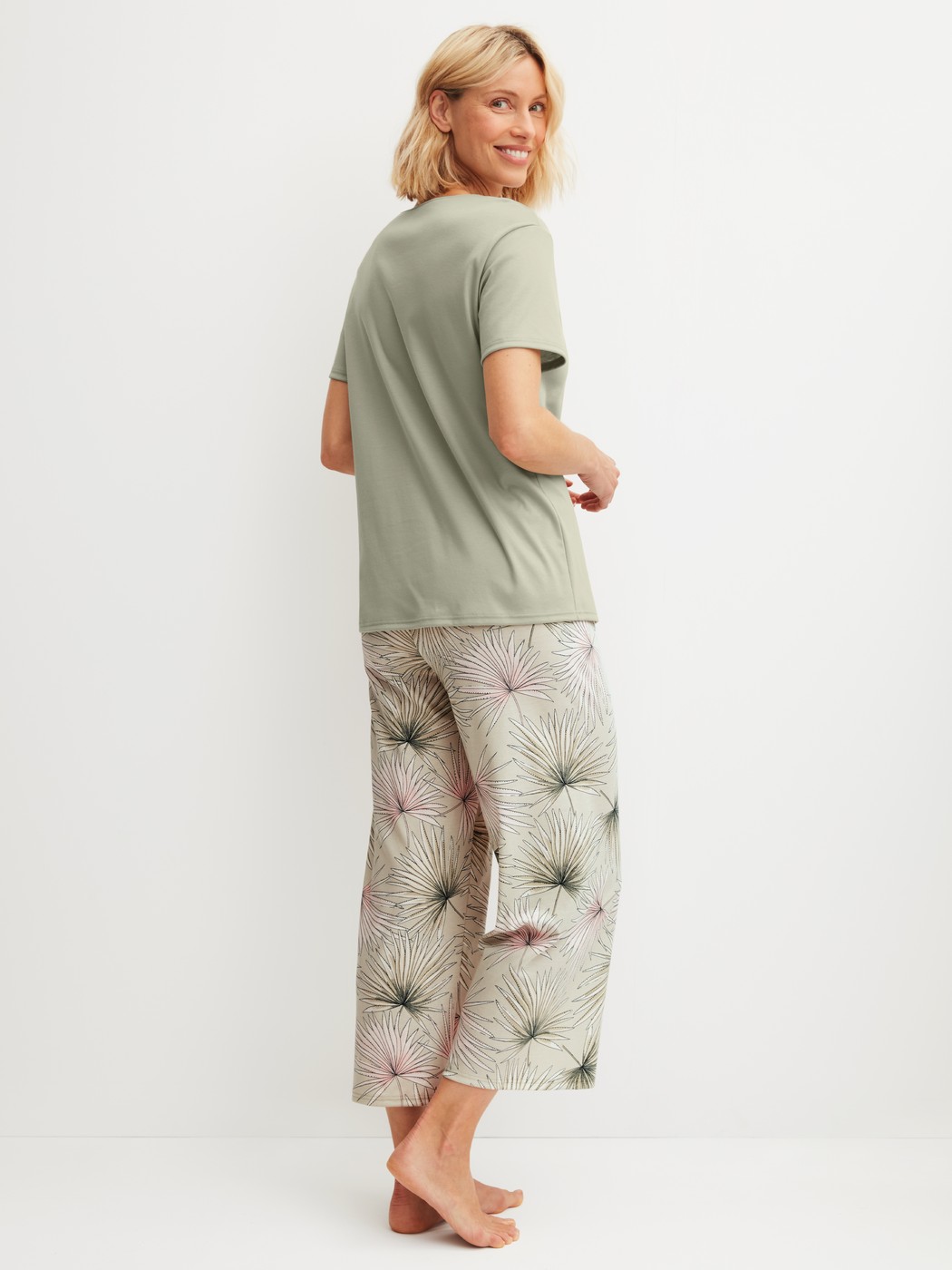 Women model is wearing 7/8 - Pyjamas made of 100% Cotton in Green, Floral from the Leaf Dreams series by CALIDA, Back view