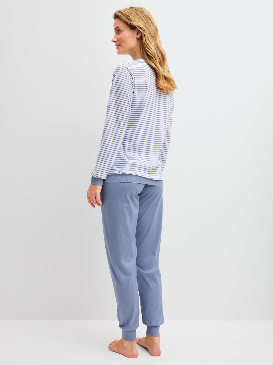 Damen-Model trägt Bündchen-Pyjama aus 100% Baumwolle in Blau, Gestreift aus Serie Cotton Special von CALIDA, Rückansicht