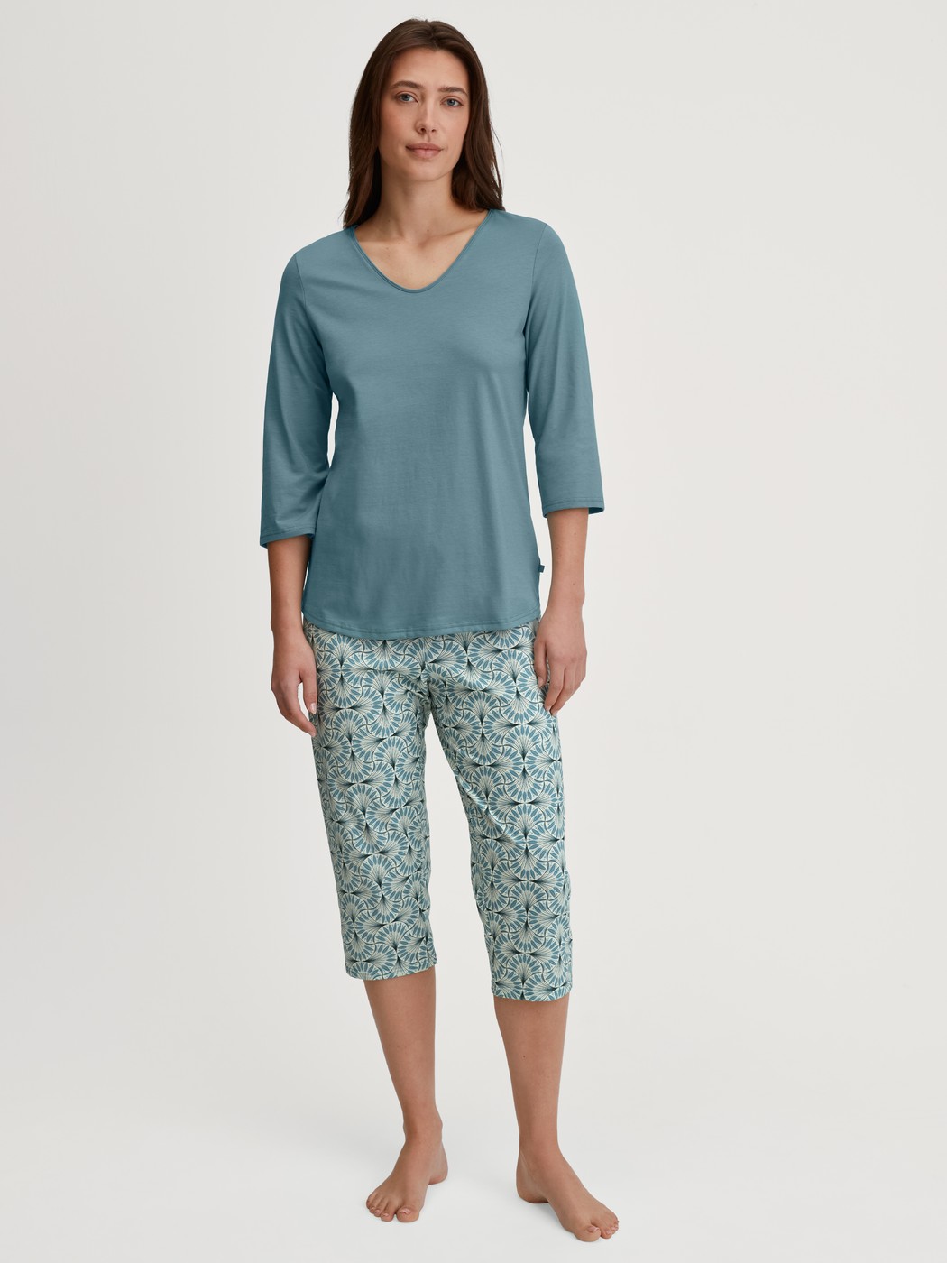 Damen-Model trägt Capri-Pyjama aus 100% Baumwolle in Blau, Gemustert aus Serie Ornament Nights von CALIDA, Vorderansicht