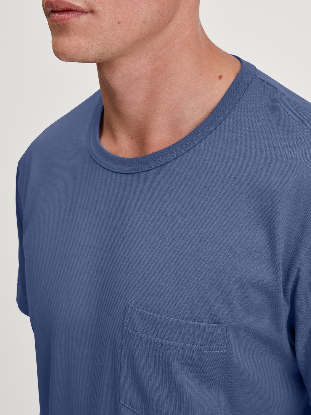 Herren-Model trägt Kurz-Pyjama aus 100% Baumwolle in Blau, Gemustert aus Serie Relax Imprint 1 von CALIDA, Detail