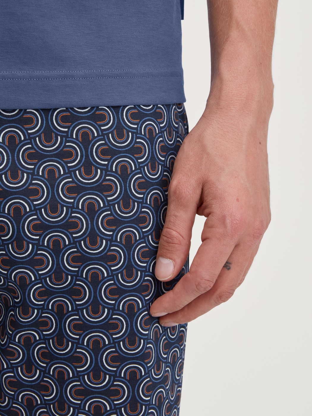Herren-Model trägt Kurz-Pyjama aus 100% Baumwolle in Blau, Gemustert aus Serie Relax Imprint 1 von CALIDA, Detail
