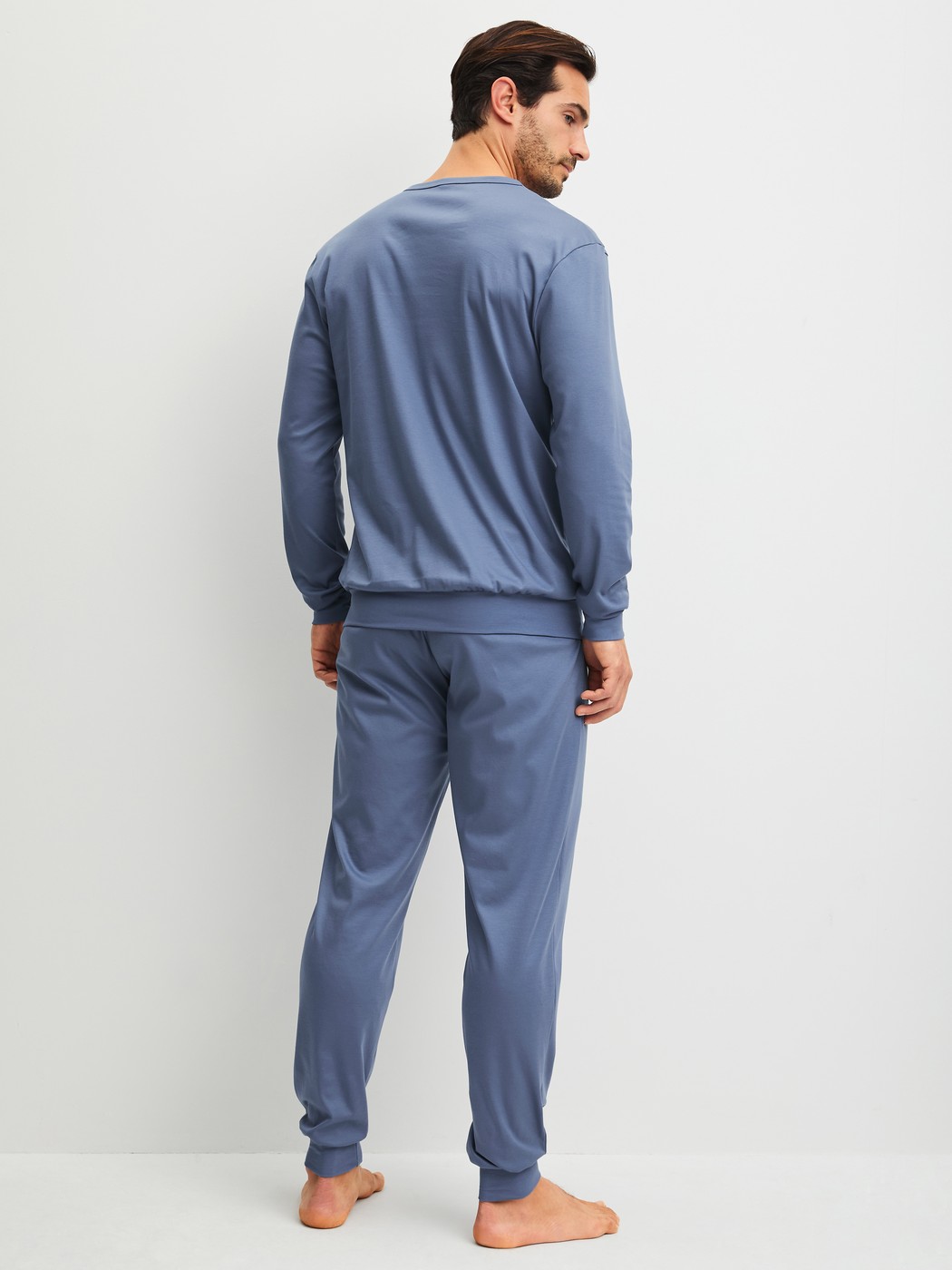Men model is wearing cuffed pyjamas made of 100% Cotton in Blue, Unicoloured from the Relax Choice 1 series by CALIDA, Back view