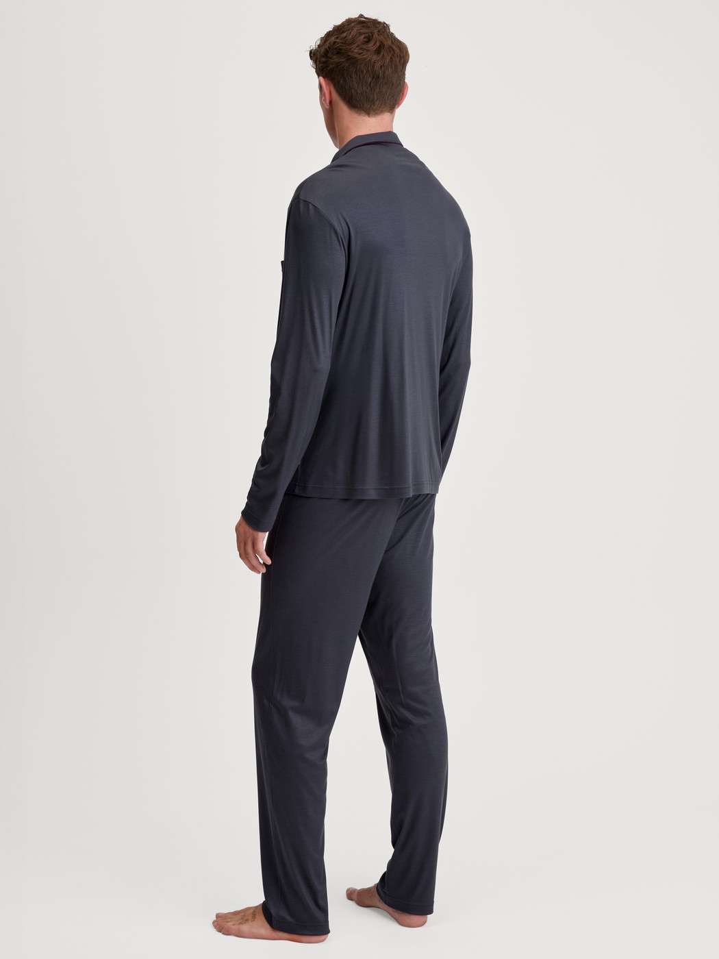 Herren-Model trägt Pyjama mit Knöpfen aus TENCEL™ in Grau, Einfarbig aus Serie Relax Silk von CALIDA, Rückansicht