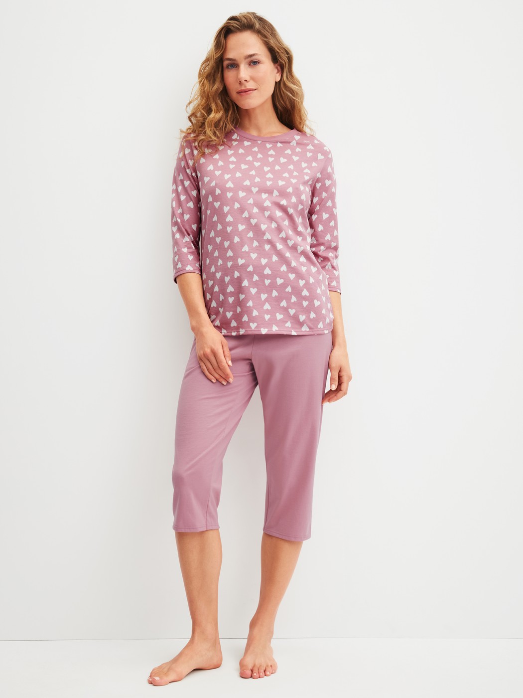 Damen-Model trägt Capri-Pyjama aus 100% Baumwolle in Rosa, Gemustert aus Serie Cotton Special von CALIDA, Vorderansicht