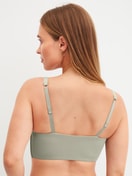 Damen-Model trägt Bustier mit verstellbaren Trägern aus Modal in Grün, Einfarbig aus Serie Natural Skin von CALIDA, Rückansicht