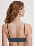 Damen-Model trägt Bustier aus Polyamid in Grün, Einfarbig aus Serie Sleek Skin von CALIDA, Rückansicht