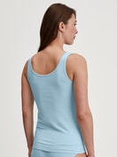 Damen-Model trägt Tank-Top aus Baumwolle in Blau, Einfarbig aus Serie Essential Cotton von CALIDA, Rückansicht