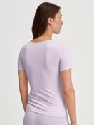 Damen-Model trägt T-Shirt, Rundhals aus Baumwolle in Violett, Einfarbig aus Serie Natural Comfort von CALIDA, Rückansicht