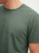 Herren-Model trägt Kurzarm-Shirt aus 100% Baumwolle in Grün, Einfarbig aus Serie RMX Sleep Leisure von CALIDA, Detail