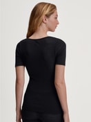 Damen-Model trägt Kurzarm-Shirt aus Wolle-Seide aus Spitze in Schwarz, Spitze aus Serie Silky Wool Glam von CALIDA, Rückansicht