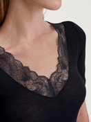 Damen-Model trägt Kurzarm-Shirt aus Wolle-Seide aus Spitze in Schwarz, Spitze aus Serie Silky Wool Glam von CALIDA, Detail