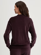 Damen-Model trägt Lounge-Jacke aus Velours aus Baumwolle in Rot, Einfarbig aus Serie Lounge Velours von CALIDA, Rückansicht