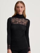 Damen-Model trägt Langarm-Shirt mit Rollkragen aus Wolle-Seide aus Spitze in Schwarz, Spitze aus Serie Silky Wool Glam von CALIDA, Vorderansicht
