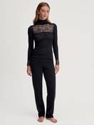 Damen-Model trägt Langarm-Shirt mit Rollkragen aus Wolle-Seide aus Spitze in Schwarz, Spitze aus Serie Silky Wool Glam von CALIDA, Outfit