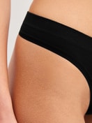 Damen-Model trägt String aus Modal in Schwarz, Einfarbig aus Serie Seamless Natural von CALIDA, Detail