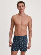 Herren-Model trägt Boxershorts mit Eingriff aus 100% Baumwolle in Blau, Motiv aus Serie Swiss Resort von CALIDA, Outfit