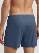 Herren-Model trägt Boxershorts, 2er-Pack aus 100% Baumwolle in Blau, Gemustert aus Serie Daywear Xtra von CALIDA, Rückansicht