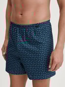 Men model is wearing Boxer shorts made of 100% Cotton in Blue, Patterned from the Prints series by CALIDA, Front view