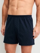 Men model is wearing Boxer shorts made of 100% Cotton in Blue, Patterned from the Prints series by CALIDA, Front view