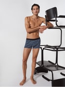 Herren-Model trägt Boxer Brief mit Softgummibund aus Baumwolle in Schwarz, Gemustert aus Serie Grafic Cotton von CALIDA, Vorderansicht