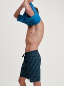 Herren-Model trägt Bermudas aus 100% Baumwolle in Schwarz, Gemustert aus Serie RMX Sleep Leisure von CALIDA, Zusatzbild