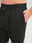 Herren-Model trägt Bermudas mit Seitentaschen aus Baumwolle in Schwarz, Einfarbig aus Serie RMX Lounge Lecce von CALIDA, Detail
