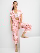 Le mannequin Femme porte le/la Pantalon de pyjama 7/8 en 100% coton de couleur Orange, Floral, de la série Favourites Beach de CALIDA, Tenue