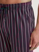 Herren-Model trägt Pyjamahose mit Seitentaschen aus 100% Baumwolle in Rot, Kariert aus Serie Remix Basic Sleep von CALIDA, Detail