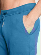 Herren-Model trägt Jogginghose mit Seitentaschen aus Baumwolle in Blau, Einfarbig aus Serie Remix Xtra von CALIDA, Detail