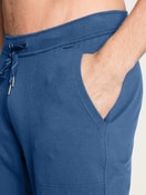 Herren-Model trägt Jogginghose mit Seitentaschen aus Baumwolle in Blau, Einfarbig aus Serie Remix Xtra von CALIDA, Detail