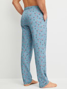 Herren-Model trägt Pyjamahose mit Seitentaschen aus 100% Baumwolle in Blau, Gemustert aus Serie RMX Sleep Holiday von CALIDA, Rückansicht