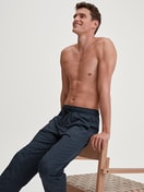 Herren-Model trägt Pyjamahose mit Seitentaschen aus 100% Baumwolle in Blau, Gemustert aus Serie RMX Sleep Weekend von CALIDA, Vorderansicht