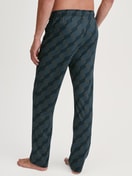Herren-Model trägt Pyjamahose mit Seitentaschen aus 100% Baumwolle in Schwarz, Gemustert aus Serie RMX Sleep Leisure von CALIDA, Rückansicht