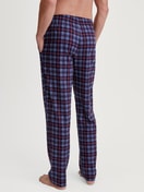 Herren-Model trägt Pyjamahose mit Seitentaschen aus 100% Baumwolle in Blau, Gemustert aus Serie Family & Friends von CALIDA, Rückansicht