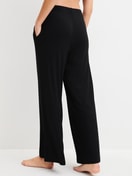 Damen-Model trägt Loungehose aus TENCEL™ Modal aus Modal in Schwarz, Einfarbig aus Serie Feminine Lounge von CALIDA, Rückansicht
