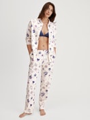 Damen-Model trägt Pyjamahose mit Seitentaschen aus 100% Baumwolle in Beige, Gemustert aus Serie Favourites Universe von CALIDA, Outfit