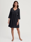 Damen-Model trägt Hauskleid, Länge 90 cm aus Baumwolle in Schwarz, Gemustert aus Serie Favourites Journey von CALIDA, Vorderansicht