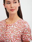 La modella / Il modello Donna indossa Camicia da notte a maniche corte, lunghezza 95 cm in 100% cotone di colore Rosso, Floreale, della serie Flower Nights di CALIDA, Dettaglio