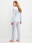 Women model is wearing Button-Up Pyjama made of 100% Cotton in Blue, Striped from the Striped Dreams series by CALIDA, Back view