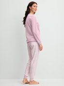 Damen-Model trägt Bündchen-Pyjama aus 100% Baumwolle in Violett, Gemustert aus Serie Blooming Nights von CALIDA, Rückansicht