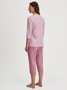 Damen-Model trägt Capri-Pyjama aus 100% Baumwolle in Rosa, Gestreift aus Serie Striped Dreams von CALIDA, Rückansicht