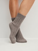 Damen-Model trägt Stricksocken aus Wolle in Braun,  aus Serie Alpine M&M von CALIDA, Vorderansicht