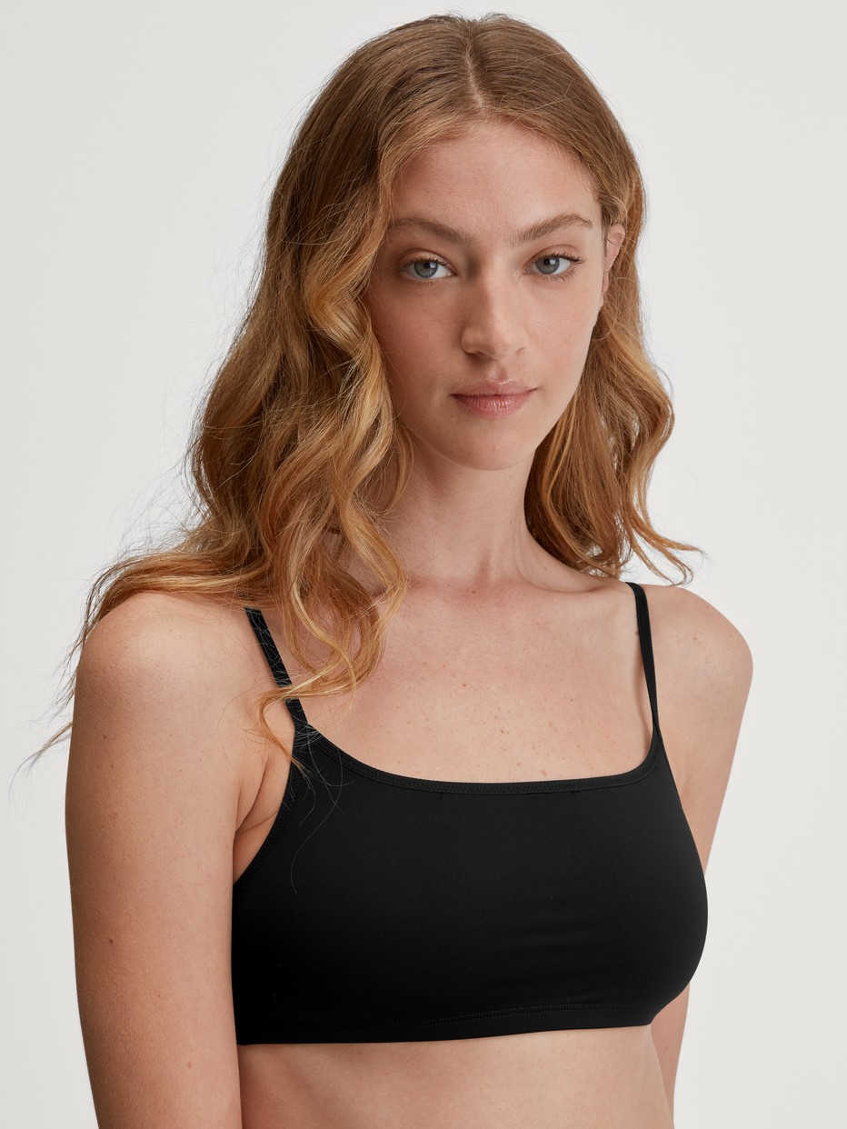 Damen-Model trägt Bustier aus Baumwolle in Schwarz, Einfarbig aus Serie Sleek Skin von CALIDA, Vorderansicht