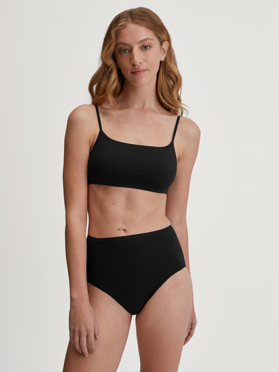 Damen-Model trägt Bustier aus Baumwolle in Schwarz, Einfarbig aus Serie Sleek Skin von CALIDA, Outfit