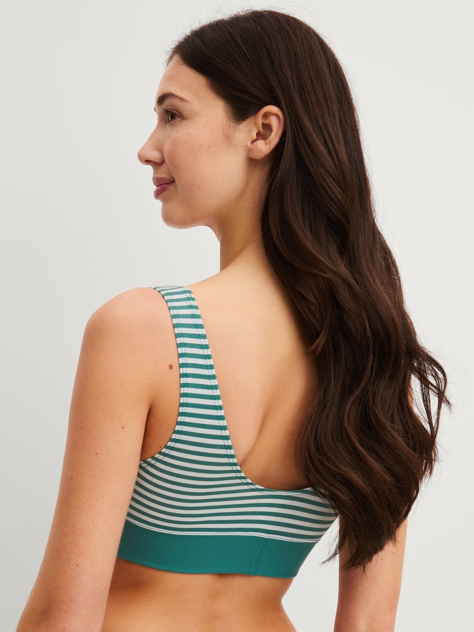 Damen-Model trägt Bustier mit Softbund aus Baumwolle in Grün, Gestreift aus Serie Elastic Special von CALIDA, Rückansicht