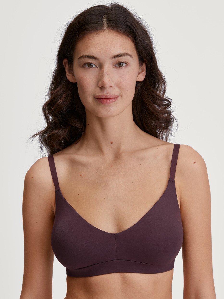 Damen-Model trägt Bustier mit verstellbaren Trägern & herausnehmbaren Pads aus Modal in Rot, Einfarbig aus Serie Natural Skin von CALIDA, Vorderansicht