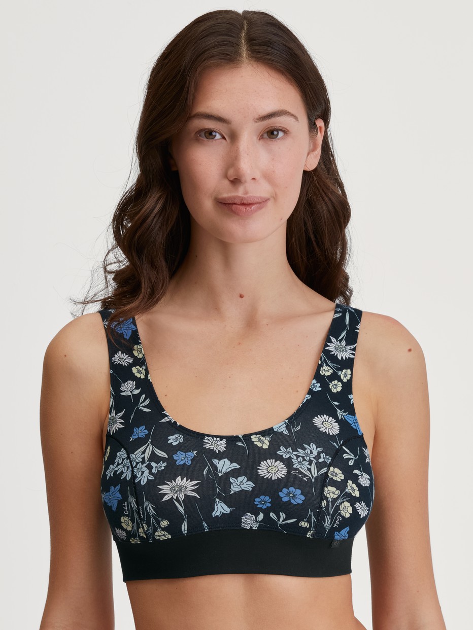 Damen-Model trägt Bustier mit Softbund aus Baumwolle in Schwarz, Floral aus Serie Elastic Trend von CALIDA, Vorderansicht