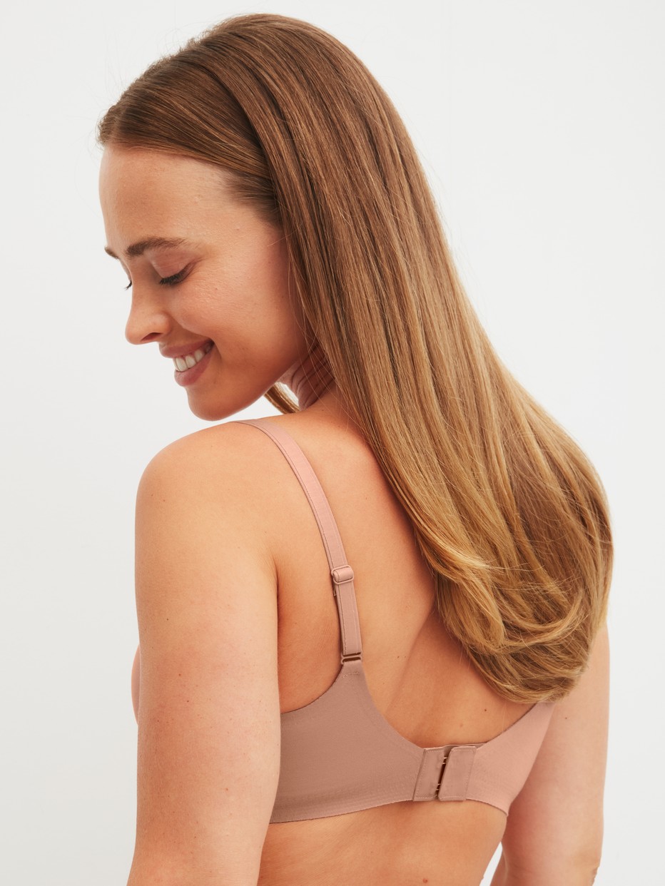 Damen-Model trägt Soft-BH mit herausnehmbaren Pads aus Modal in Grau, Einfarbig aus Serie Natural Skin von CALIDA, Rückansicht