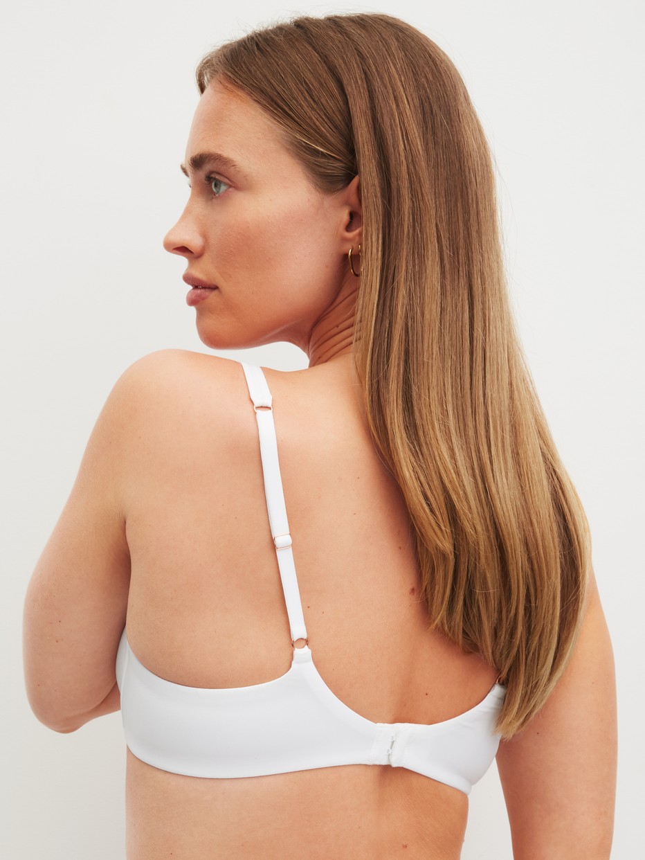 Damen-Model trägt Bügel-BH aus Polyamid in Weiß, Einfarbig aus Serie Sleek Skin von CALIDA, Rückansicht